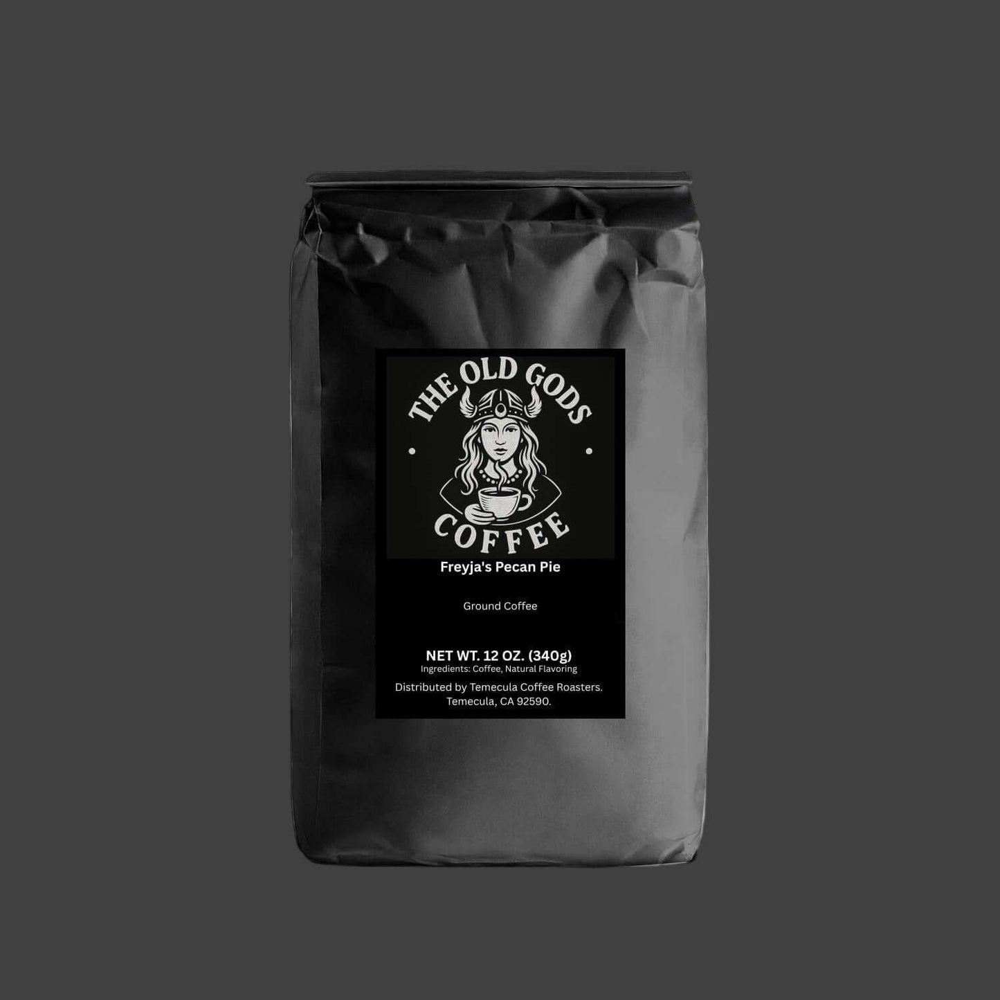 The Old Gods Coffee Freyja's Pecan Pie flavored ground coffee, featuring a Norse goddess in a horned helmet holding a steaming coffee cup, with product details for 12 oz. (340g) distributed by Temecula Coffee Roasters."