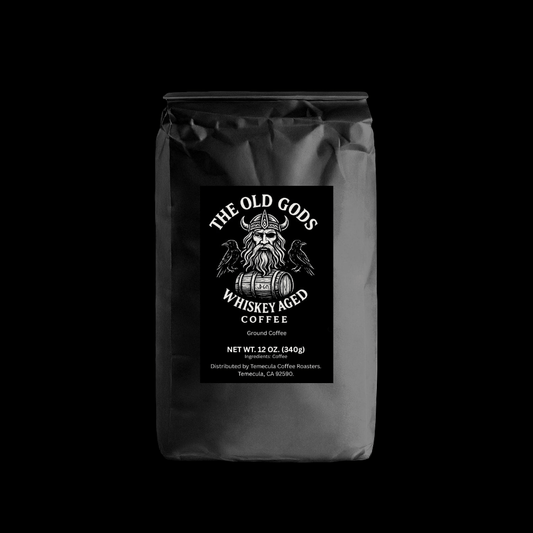 Whiskey Aged Coffee bag featuring The Old Gods branding and ground coffee details.
