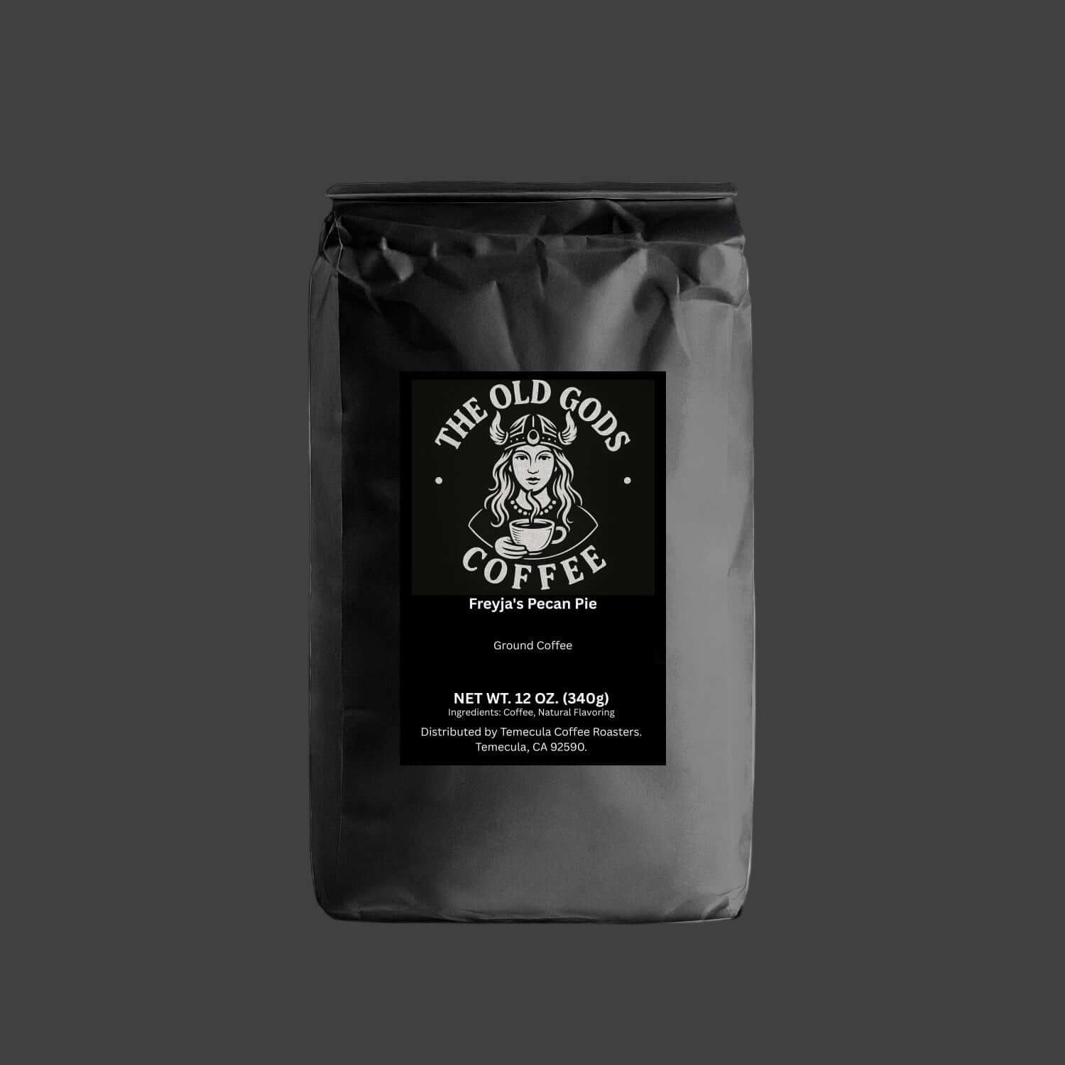 The Old Gods Coffee Freyja's Pecan Pie flavored ground coffee, featuring a Norse goddess in a horned helmet holding a steaming coffee cup, with product details for 12 oz. (340g) distributed by Temecula Coffee Roasters."
